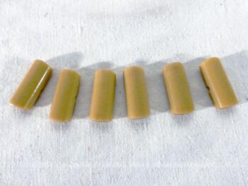 Voici un lot vintage de 6 boutons de couleur beige/crème en forme de 1/2 cylindre. de 3 x 1.2 x 0.5 cm avec 2 interstices sur les cotés pour les coudre.