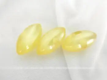 Voici un lot de 3 petits boutons ovoïdes de couleur jaune paille irisé avec deux trous discrets dans les cotés pour les coudre.