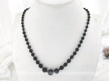 Sur 57 cm de long, voici un superbe collier ras de cou en perles de verre noires à facettes noire, de taille croissante jusqu'au centre, un noeud entre chaque perle.