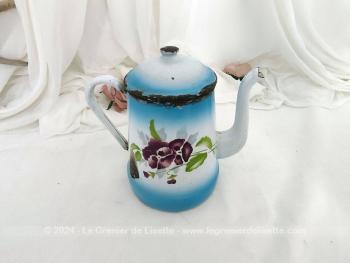 Voici une ancienne cafetière habillé d'un fond bleu ciel et blanc en émail et décorée de grosses pensées violettes sans oublier son couvercle et tout le charme de l'authentique avec ses éclats.