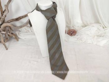 Voici une superbe cravate vintage seventeen de la marque Giorgio Armani décorée de motifs décoré gris et taupe avec renfort satiné au cou et doublure estampille Giorgio Armani.