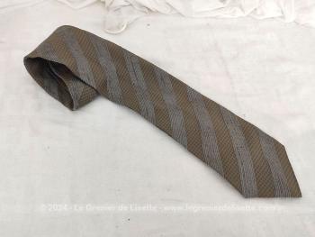 Voici une superbe cravate vintage seventeen de la marque Giorgio Armani décorée de motifs décoré gris et taupe avec renfort satiné au cou et doublure estampille Giorgio Armani.
