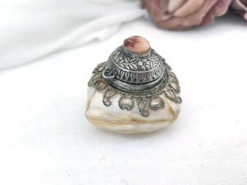 Adorable petite boite à tabac, à chapelet composée de différents morceaux de nacre  serti d'un couvercle en métal argenté ouvragé et ciselé  surmonté par une perle en coquillage.