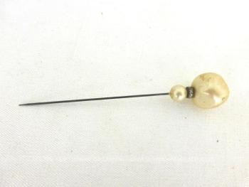 Sur 9.5 cm de long, voici une ancienne épingle à chapeau composée d'une perle en verre à facettes aléatoires  recouverte d'un vernis nacre, d'un petit anneau métallique habillé de strass et d'une petite perle nacrée toute ronde. Idéale pour chapeaux ou en décoration.