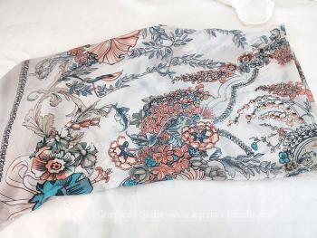 Sur 118 x 118  cm, voici un très original foulard ou étole 50 % soie et 50% viscose avec sur un fond gris perlé, de grands bouquets de fleurs aux tons saumon et bleu lagon. Effet aérien garanti. Made in PCR,