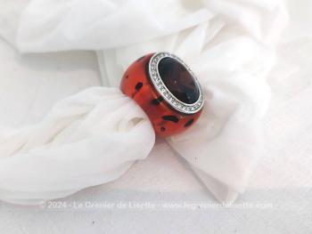 D'une forme vintage, voici une belle bague en résine, surmontée d'une pierre en verre couleur ambre à facettes sertie dans du métal décoré de strass. Parfait pour doigt très fin car ouverture de 1.85 cm de diamètre.