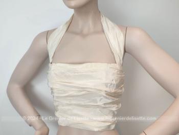 Voici un superbe bustier composé de plis en tissus soyeux couleur ivoire ou beige de la marque vintage Création Flory Paris. Original, il se ferme par deux larges liens au dos.