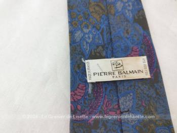 Voici une superbe cravate vintage de la marque Pierre Balmain 100 % soie et décorée motifs fleurs, arabesques dans  les tons dégradés de fuchsia, beige et gris avec étiquette Pierre Balmain Paris Made in France.