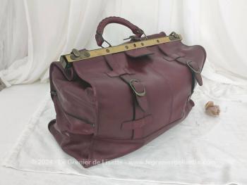 Voici un superbe grand sac de voyage en cuir bordeaux avec une belle forme d'ancienne sacoche de docteur  avec toutes ses poches intérieures et ses 2 grandes ceintures pour fermer le sac.