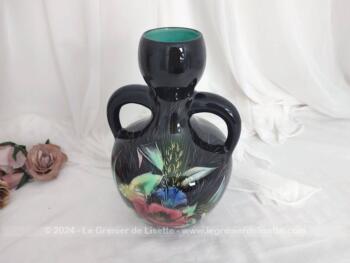 Datant des années 60, voici un superbe vase à double anses sur fond noir avec des dessins de fleurs colorées, provenant des faïences Monacera de Monaco. Vintage !