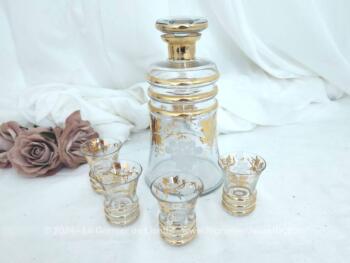 Voici un adorable service à liqueur composé d'une grande carafe et ses 4 verres assortis, le tout décoré de belles dorures et de grappes gravées. Vintage comme on aime !