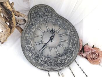 Voici une superbe pendule en étain bien ouvragée fonctionnant avec une pile pour faire tourner les aiguilles et activer le balancier. Elle a tout pour donner l'impression d'une ancienne pendule avec balancier et poids. Vraiment belle et très décorative.