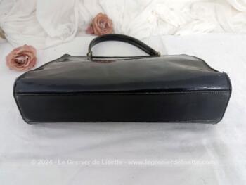 Voici un sac vintage en cuir vernis noir avec une poche intérieure simple et une fermée par une fermeture éclair. Il se ferme par un fermoir à clapet. Sa anse lui permet de le porter à la main, au bras et même à l'épaule. Top vintage !